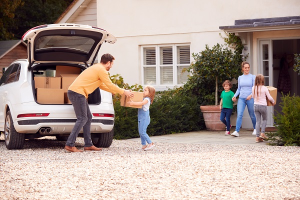 unloading a car in front of a house