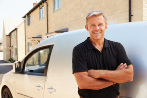 man standing in front of company van